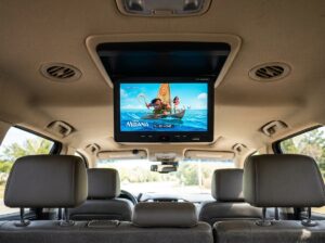Widescreen overhead flip down DVD monitor open and active in vehicle cabin